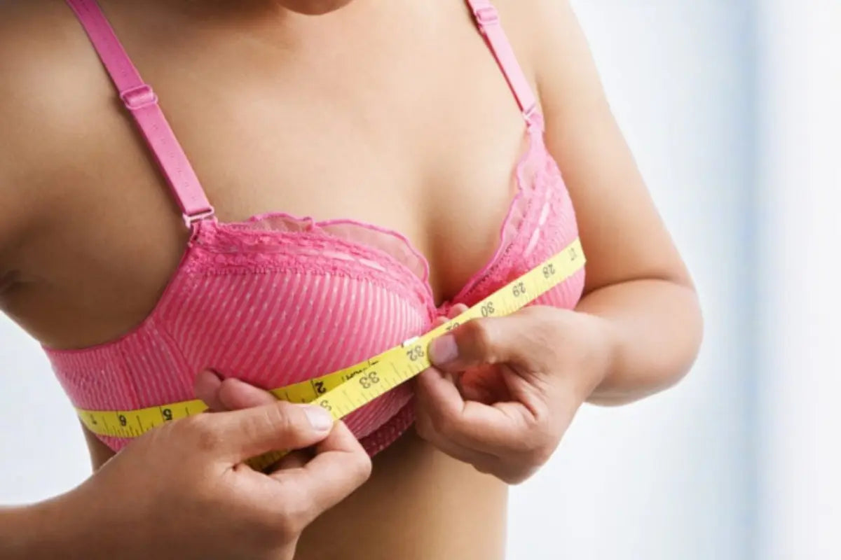 Bralettes for bigger busts shown as a woman measures her bust size over a supportive pink lace bralette.