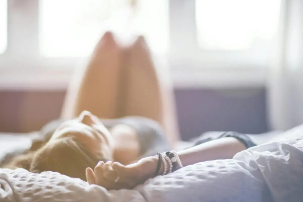 No wire bralette worn by a woman relaxing on a bed in soft natural light.