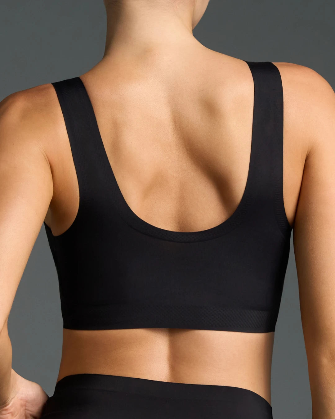 Back view of black wireless bra showing scoop back and wide seamless straps.
