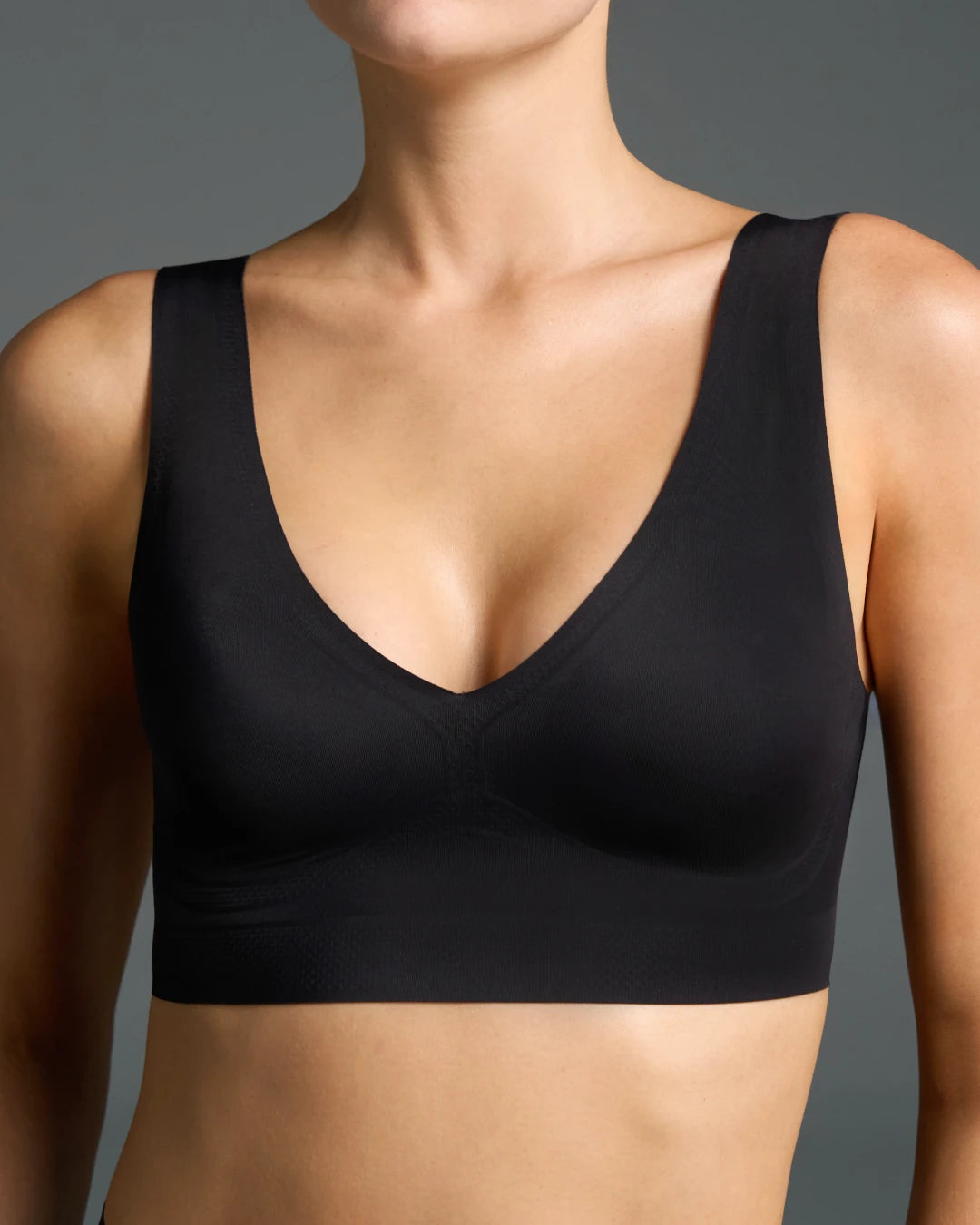 Model wearing a black seamless wireless bra with a deep V neckline.