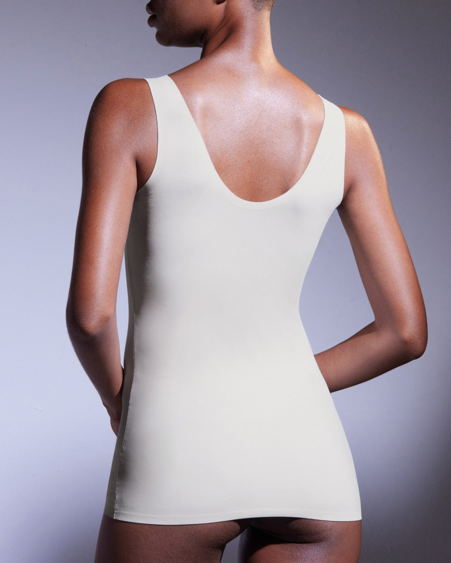 Model shown from behind in a pearl seamless tank top with a scoop back.