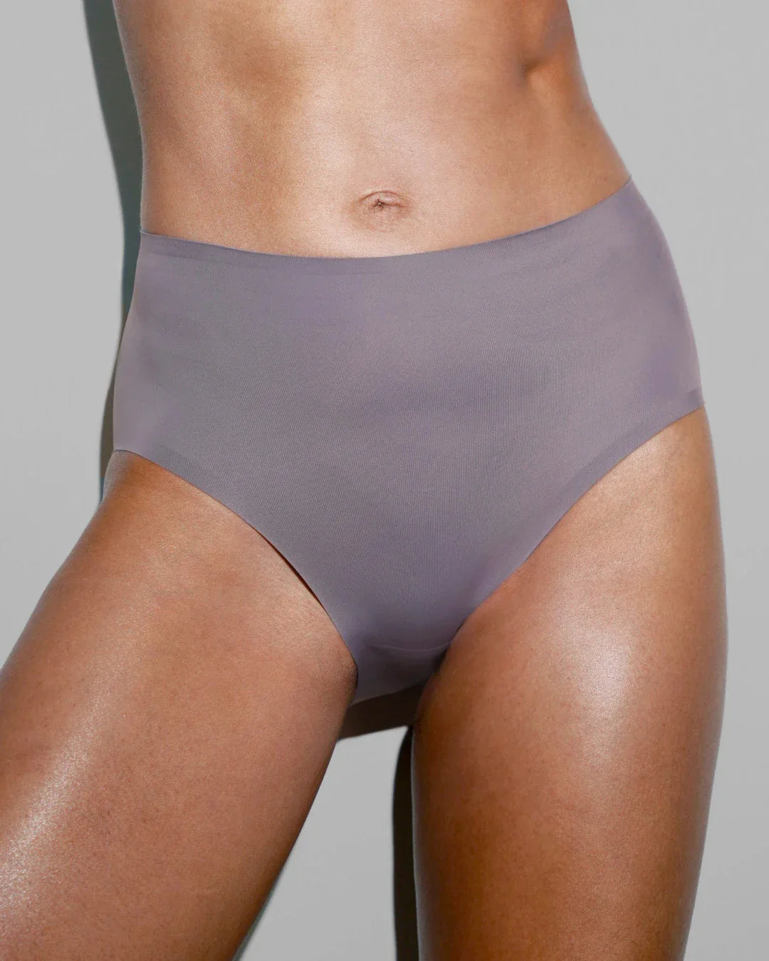Close-up of slate gray seamless high-waisted briefs with laser-cut edges on model