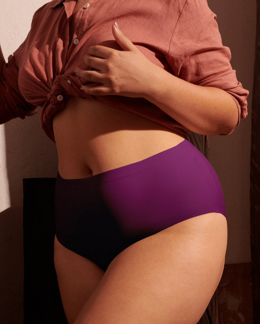 Model wearing purple Charisma high waisted seamless panty with a tied rust linen shirt.