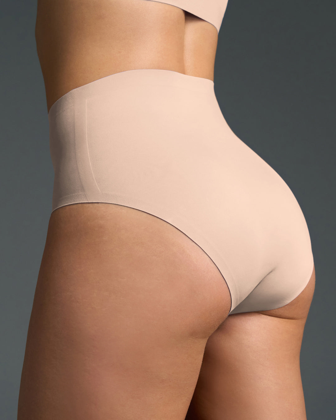 Beige no show high waist panties shown from the back, featuring a seamless high-rise cut with smooth stretch fabric for invisible coverage and a comfortable, sculpted fit