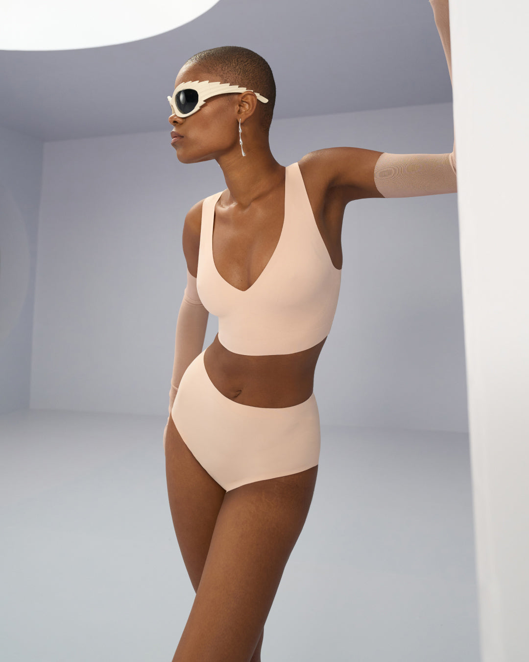 Beige seamless bralette top and high waisted seamless panty set shown on model, featuring a smooth, stretch fabric with clean edges for a sleek, invisible fit and modern minimalist style