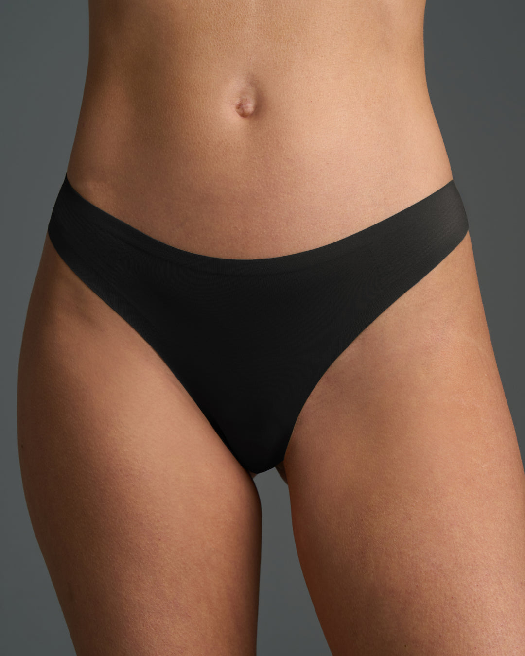 Front view of model wearing a seamless thong with a smooth no-show waistband.
