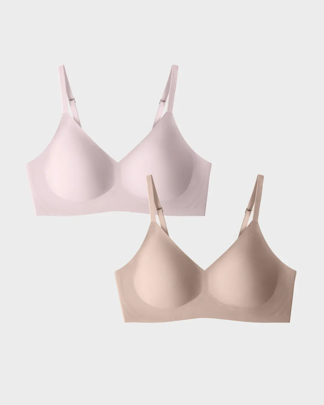 Wireless T-shirt bra two-pack in blush and nude with V-neckline, molded cups, and adjustable straps.