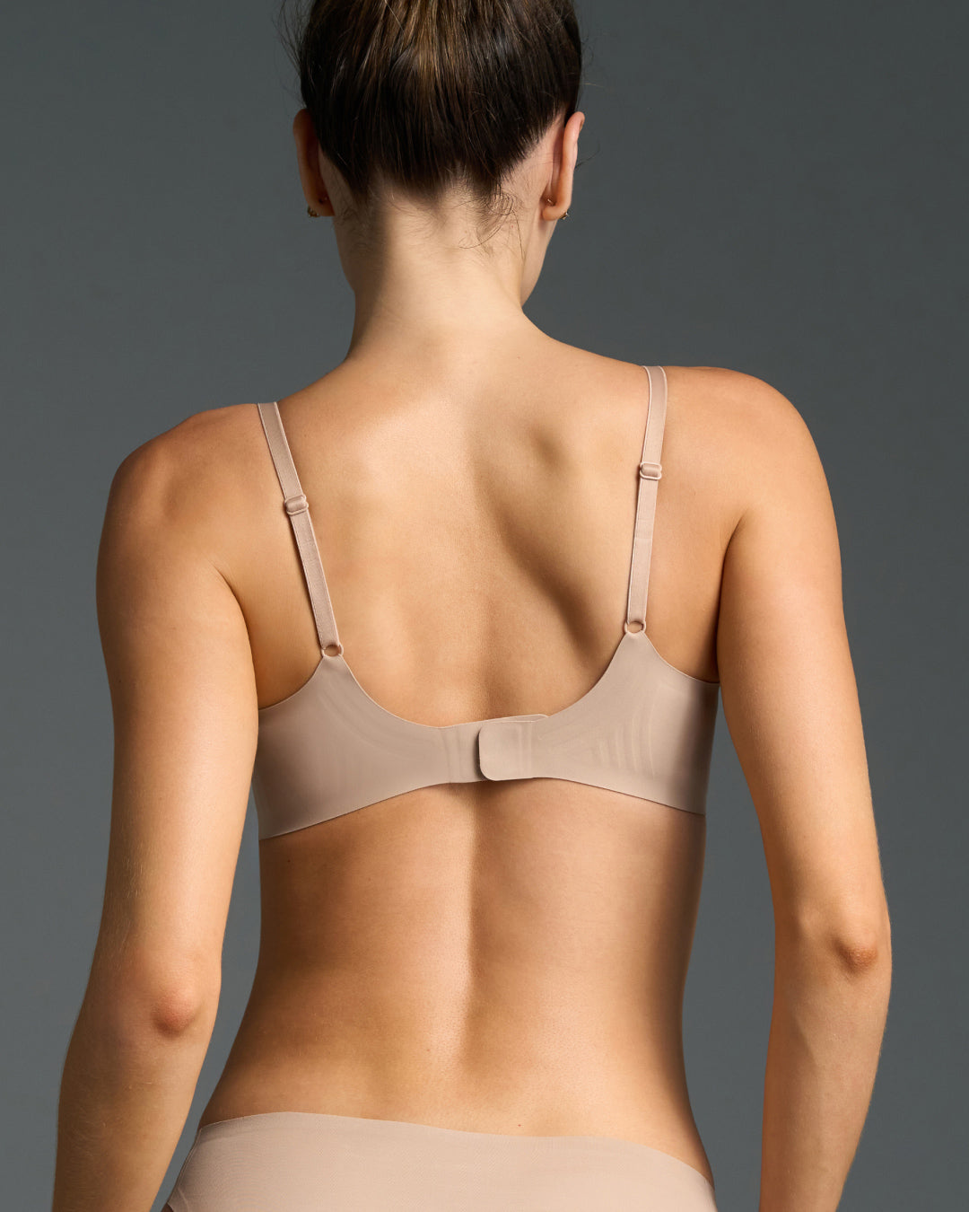 Close-up of model wearing nude relief bra showing smooth cup detail.