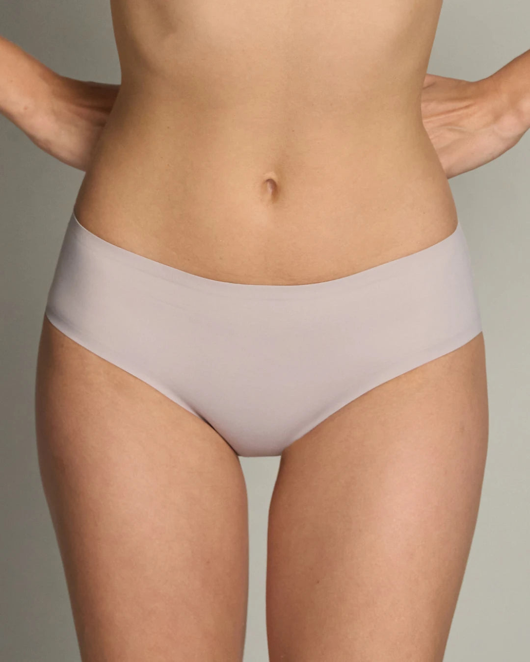 Model wearing EBY Raindrop seamless brief in soft mauve, front view showing no-show edges.