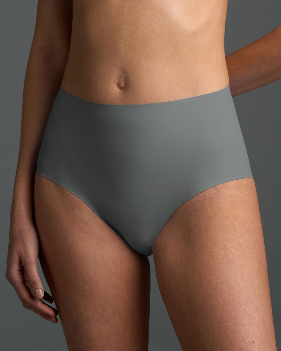Gray no show high waist brief panty shown on model, featuring a sleek high-rise fit with seamless edges and smooth stretch fabric for invisible comfort under clothing